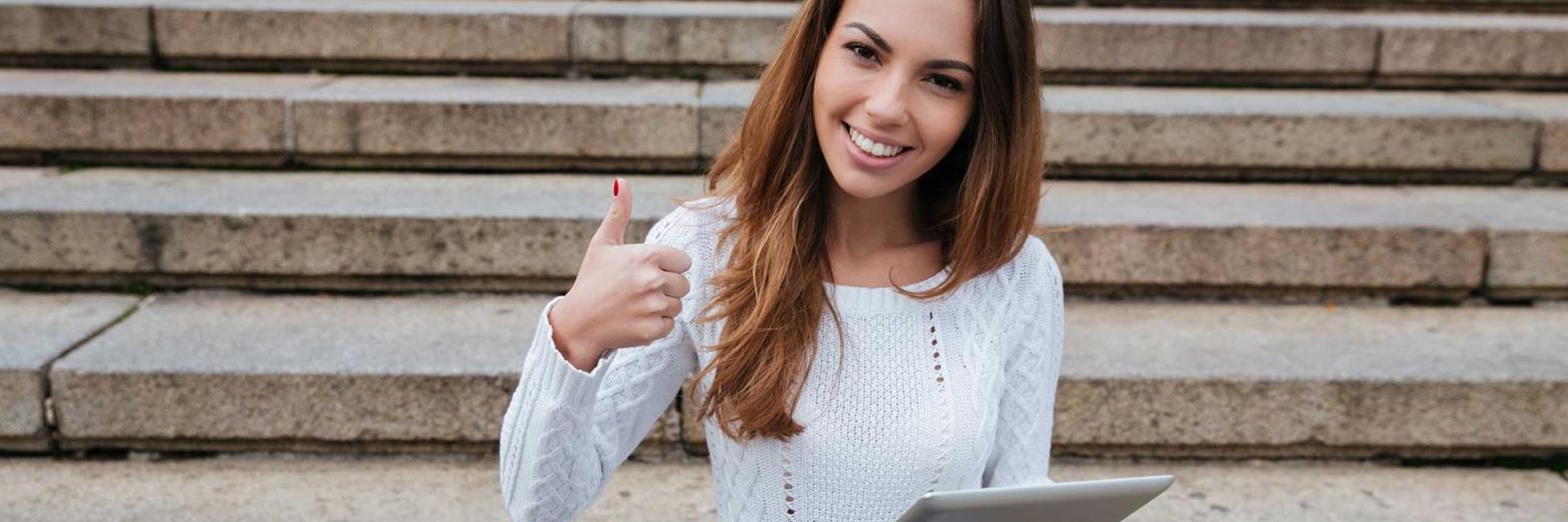 Eine junge Dame freut sich, durch das ganzheitliche Bewerbungstraining von Instructainment, ihren perfekten Job zu haben.